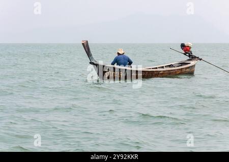 Phang Nga, Thaïlande - 26 octobre 2016 : un pêcheur solitaire navigue dans des eaux tranquilles. Banque D'Images