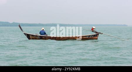 Phang Nga, Thaïlande - 26 octobre 2016 : un pêcheur solitaire navigue dans des eaux tranquilles. Banque D'Images