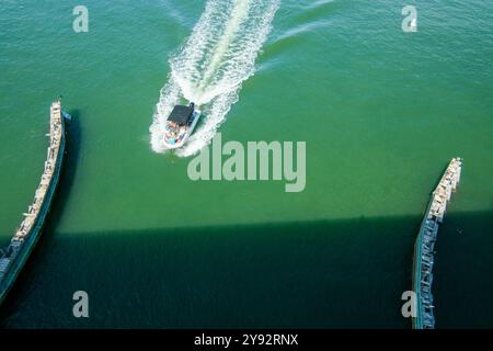 Clearwater, FL, États-Unis - 02 Oct 2024 - Un bateau de plaisance entrant dans un canal dans les eaux vertes de Floride après une tempête Banque D'Images