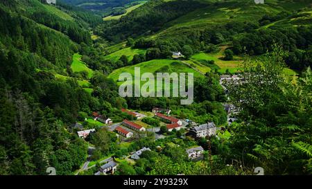 Vue du village de Ceinws depuis le haut montrant des bâtiments dans la vallée boisée et la forêt près de Machynlleth Powys Wales UK Banque D'Images