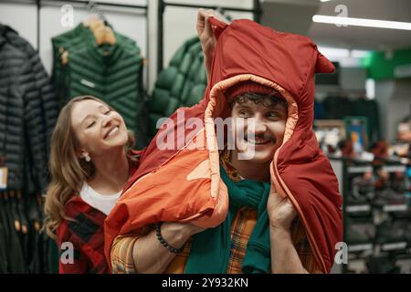 Homme et femme ravis de magasiner à la boutique de vêtements de sport Banque D'Images