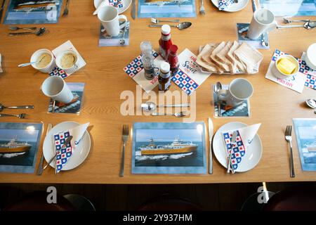 Des tapis de table avec une photo du Kirkella dans le restaurant / salle à manger à bord du Kirkella. Le Kirkella est un congélateur britannique de morue et d'églefin Banque D'Images