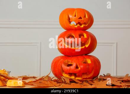 Citrouilles d'Halloween sculptées dans des visages créatifs placés dans une pile Banque D'Images