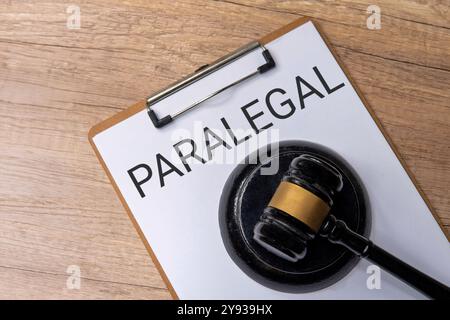 Un presse-papiers avec le mot « PARAJURISTE » et juge marteau. Concept de loi. Banque D'Images