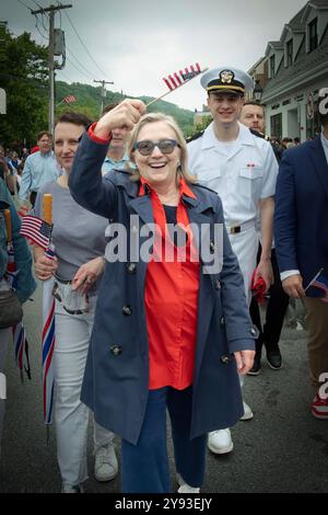 Une joyeuse Hillary Clinton marchant et agitant un drapeau américain lors de la parade du Memorial Day 2024 à Chappaqua, NYC. Bill était là aussi. Banque D'Images