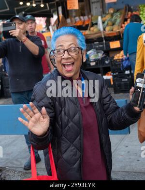 Une femme plus âgée, peut-être dans la soixantaine, avec des cheveux cyan bleu vif. Au défilé Dominicain Day sur la 37e Avenue à Jackson Heights, Queens. Banque D'Images