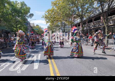 Les danseurs TKSS en costumes colorés incroyables défilent sur la 37e avenue à Jackson Heights lors de la parade du jour du patrimoine hispanique. Banque D'Images