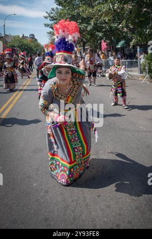 Une bolivienne américaine d'âge moyen vêtue d'un brillant costume danse au défilé du jour du patrimoine hispanique à Jackson Heights, Queens, New York. Banque D'Images