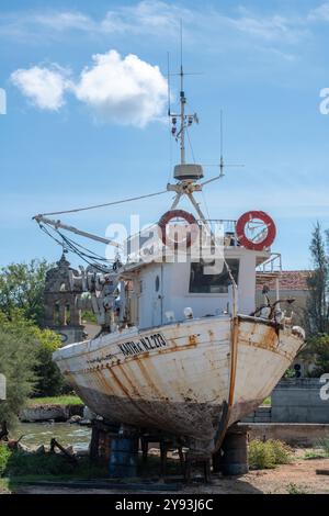 Vieux bateau de pêche traditionnel grec en bois haut et sec hors de l'eau dans un chantier naval pour l'entretien essentiel. Banque D'Images