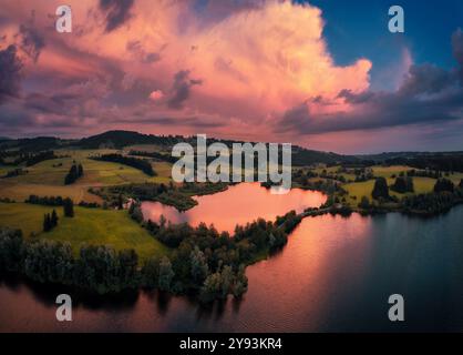 Vue aérienne spectaculaire d'un lac pittoresque dans une lumière rouge spectaculaire. Tourné en Bavière, en Allemagne, avec des nuages rouges reflétés dans l'eau Banque D'Images