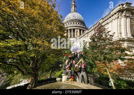 Londres, Royaume-Uni. 08 octobre 2024. Le groupe de théâtre musical Schërzo interagit et pose avec ses instruments autour de l'emblématique cathédrale Saint-Paul de Londres, en admirant les sites de leur ville hôte actuelle. Les clowns musicaux de renommée internationale joueront Släpstick : Schërzo à Londres pour la première fois du 7 au 12 octobre, au Wilton's Music Hall. Schërzo est la production la plus récente du groupe et a été présentée en première internationale au Edinburgh Fringe Festival. Crédit : Imageplotter/Alamy Live News Banque D'Images