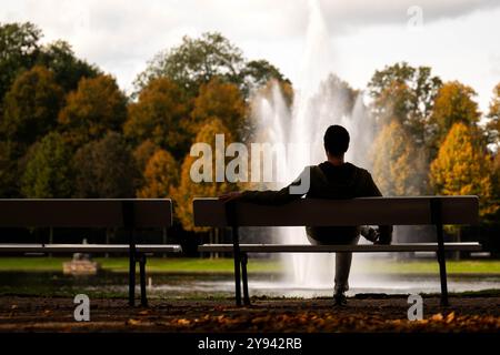 Brême, Allemagne. 08 octobre 2024. Un homme est assis sur un banc près du lac Holler See en face du Parkhotel. Crédit : Sina Schuldt/dpa/Alamy Live News Banque D'Images