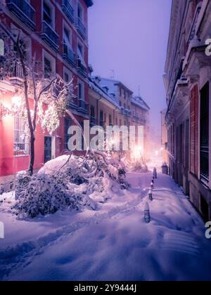 Une nuit enneigée à Madrid montre la ville couverte d'une épaisse couche de neige, avec des arbres tombés sous le poids de la neige, avec des lampadaires lumineux cas Banque D'Images