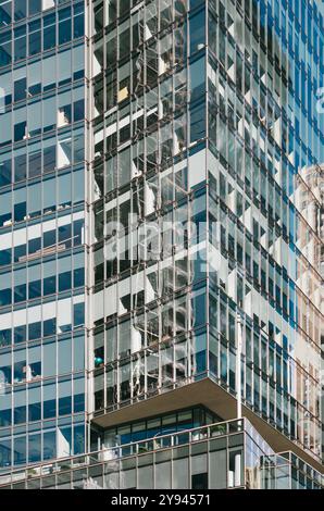 Gros plan d'un immeuble de bureaux en verre moderne à New York affichant ses fenêtres réfléchissantes et son architecture contemporaine. La façade révèle un int Banque D'Images