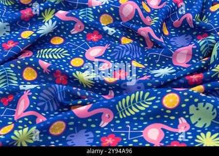 Motif de tissu de flamant rose avec des flamants roses, des agrumes et des feuilles tropicales sur un fond bleu Banque D'Images
