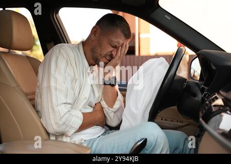 Homme blessé près d'un airbag ouvert dans une automobile après un accident de voiture Banque D'Images