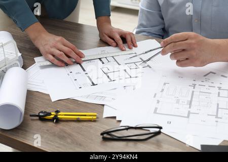 Architectes travaillant avec le projet, gros plan. Différents dessins techniques sur table en bois Banque D'Images