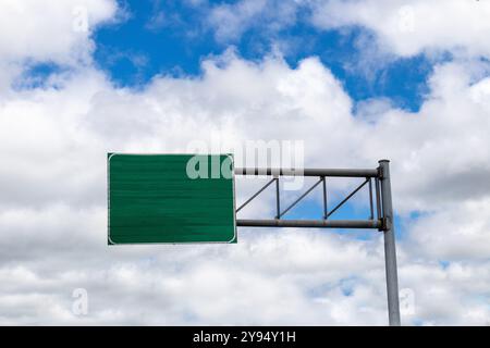 Voie rapide verte vierge ou panneau d'autoroute, vue d'angle bas contre le ciel bleu avec des nuages Banque D'Images