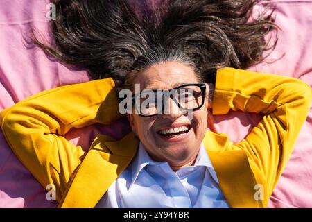 Belle femme d'affaires senior portant une tenue d'affaires décontractée se promenant dans le quartier des affaires de la ville - adulte d'entreprise mature allant travailler à Banque D'Images