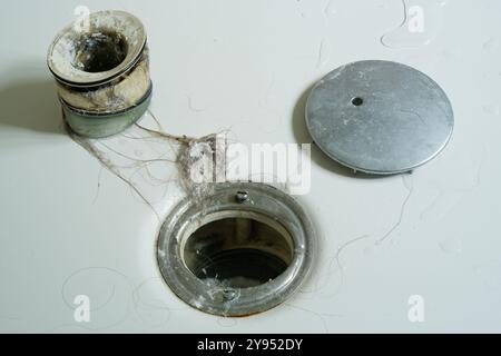 Cheveux et savon d'un drain de douche. Un mélange dégoûtant de cheveux et de savon provenant d'un trou de drainage de sortie de douche domestique. Déboucher les cheveux d'un drain bouché. Banque D'Images