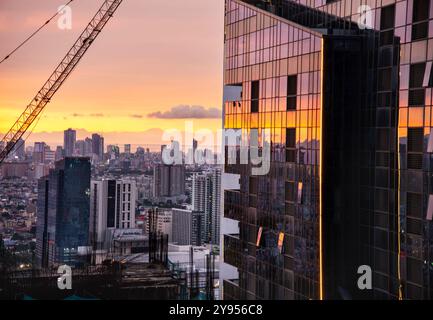 Manille, Luzon, Philippines-19 mai 2023 : le soleil couchant projette une lumière chaude à travers la métropole urbaine, un mélange environnemental intense et fortement peuplé Banque D'Images