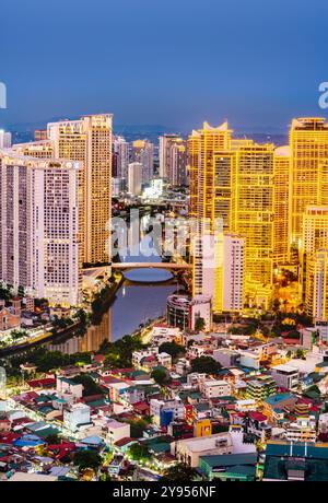 Manille, Luzon, Philippines-19 mai 2023 : les lumières de bande couvrant les hautes structures du condo et du quartier des affaires, sont allumées au crépuscule, illumin Banque D'Images