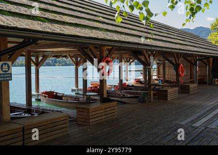 Vue sur le port avec des bateaux en bois à louer dans une jetée dans le lac de Bled. Nous pouvons voir que des gilets de sauvetage et des gilets de sauvetage rouges sont également disponibles. Banque D'Images