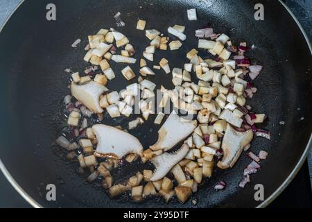 Champignons Eringi frits avec des oignons dans une poêle. Photo de haute qualité Banque D'Images