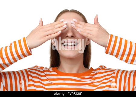 Fille souriante avec des accolades couvrant les yeux sur fond blanc Banque D'Images