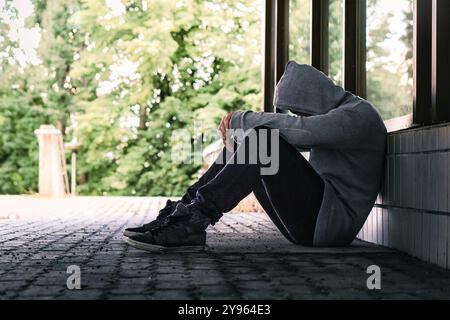 Traumatisme ou culpabilité d'un triste déprimé. Les sans-abri exclus avec toxicomanie dans la rue de la ville. Solitude, désespoir ou discrimination. Honte de la victime. Banque D'Images