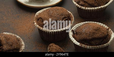 Muffins brunis au chocolat et au cacao avec cappuccino au café dans la vue d'angle de tasse sur fond de pierre rustique brun, cupcakes doux au chocolat noir faits maison, Banque D'Images