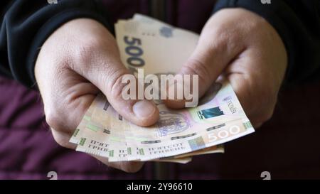 Mâle blanc montre des billets de hryvnia ukrainiens dans sa main gros plan vue de face, photographie de nourriture, photographie de nourriture Banque D'Images