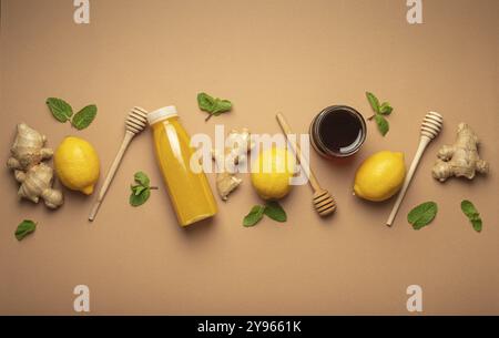 Composition avec boisson détox, citrons, menthe, gingembre, miel dans un pot en verre, trempettes en bois de miel vue de dessus. Aliment pour la stimulation de l'immunité et contre la grippe. Banque D'Images