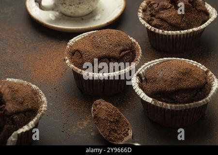 Muffins brunis au chocolat et au cacao avec cappuccino au café dans la vue d'angle de tasse sur fond de pierre rustique brun, cupcakes doux au chocolat noir faits maison, Banque D'Images