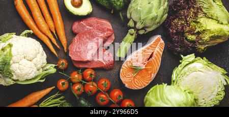 Assortiment de produits crus alimentaires : légumes, steak de viande de bœuf, filet de saumon de poisson sur la table en pierre brun rustique foncé vue du dessus. Fond de nourriture saine, ingred Banque D'Images