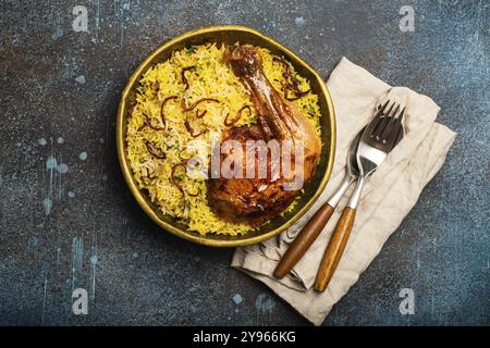 Délicieux plat indien de poulet Biryani avec riz basmati dans un ancien bol en laiton métallique sur une table rustique en pierre. Cuisine traditionnelle non végétarienne Banque D'Images