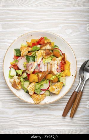 Plat traditionnel du Levant salade Fattoush, cuisine arabe, avec croûtons de pain pita, légumes, herbes. Salade végétarienne saine du moyen-Orient, woo rustique Banque D'Images