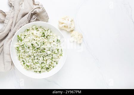 Riz chou-fleur cru ou couscous avec aneth dans un bol blanc, plat d'accompagnement végétal sain à faible teneur en glucides pour régime céto et nutriti sain à faible teneur en calories Banque D'Images