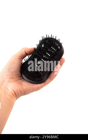 Female hand holding aroma hair comb for massage of head isolated on white background. Stock Photo