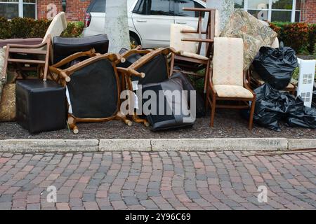 Gros tas de déchets, meubles, articles ménagers empilés sur le côté d'une bordure de rue en briques. Après une tempête endommageant l'inondation d'une onde de tempête d'eau. Attendez Banque D'Images