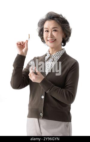 Femme âgée heureuse présentant cordyceps sinensis Banque D'Images