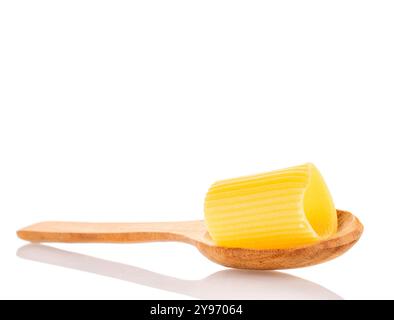 Pâtes de blé dur cannelloni crues avec cuillère en bois, macro, isolées sur fond blanc. Banque D'Images