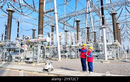 CHUZHOU, CHINE - 8 OCTOBRE 2024 - un robot intelligent et le personnel d'exploitation et de maintenance effectuent une inspection spéciale de l'équipement principal i. Banque D'Images