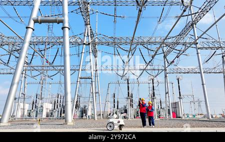 CHUZHOU, CHINE - 8 OCTOBRE 2024 - un robot intelligent et le personnel d'exploitation et de maintenance effectuent une inspection spéciale de l'équipement principal i. Banque D'Images