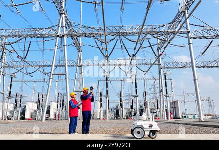 CHUZHOU, CHINE - 8 OCTOBRE 2024 - un robot intelligent et le personnel d'exploitation et de maintenance effectuent une inspection spéciale de l'équipement principal i. Banque D'Images