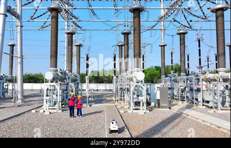 CHUZHOU, CHINE - 8 OCTOBRE 2024 - un robot intelligent et le personnel d'exploitation et de maintenance effectuent une inspection spéciale de l'équipement principal i. Banque D'Images