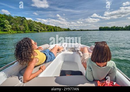 Tourisme sur la Seille, un affluent du Saône. Deux femmes à bord d'un bateau sur la rivière, profitant du paysage et du soleil *** local Caption *** Banque D'Images