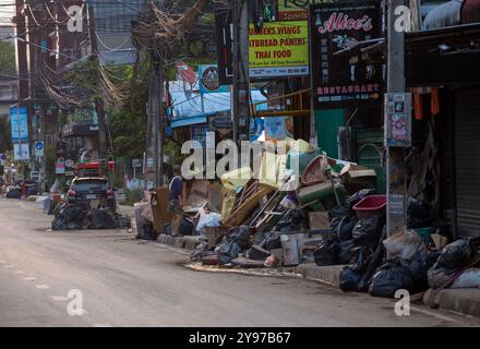 Un homme est vu debout près d'un grand tas de déchets qui a été empilé au bord de la route après que les eaux de crue ont reculé. Les habitants de Chiang mai commencent à reprendre leur vie normale après que la situation des inondations a diminué. Cependant, ils font encore face à des difficultés dans la vie quotidienne, en particulier lorsqu'ils voyagent sur des routes couvertes de boue et de poussière laissées derrière eux par les eaux qui reculent, ce qui rend les déplacements inconfortables. De plus, les ordures sont dispersées dans toute la ville car les résidents jettent des objets endommagés par les inondations, qui peuvent être vus partout. (Photo de Pongmanat Tasiri/SOPA images/Sipa USA) Banque D'Images