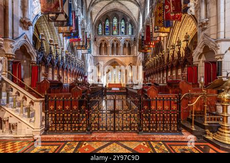 Le choeur de la cathédrale de Patrick à Dublin, en Irlande, présente une architecture gothique complexe avec des stalles de chœur soigneusement sculptées et des taches vibrantes Banque D'Images