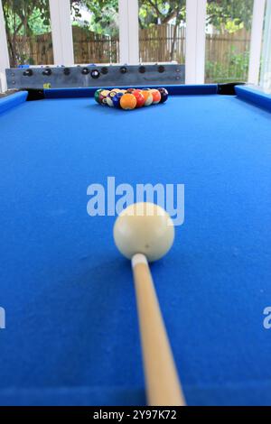 Boules de billard avec des numéros sur eux sur une table de billard bleue en action de frapper Banque D'Images